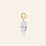 Marquise-cut diamond drop charm suspended from a polished gold loop, photographed with a subtle reflection on a warm ivory background.