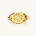 Front view of a yellow gold Reversible Dojang Ring with an ornate floral filigree band and circular face engraved with Korean Hangul and “est. 2021.”