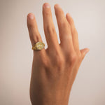 Yellow gold Reversible Dojang Ring worn on a hand, featuring a circular engraved seal face and detailed floral filigree along the sides.