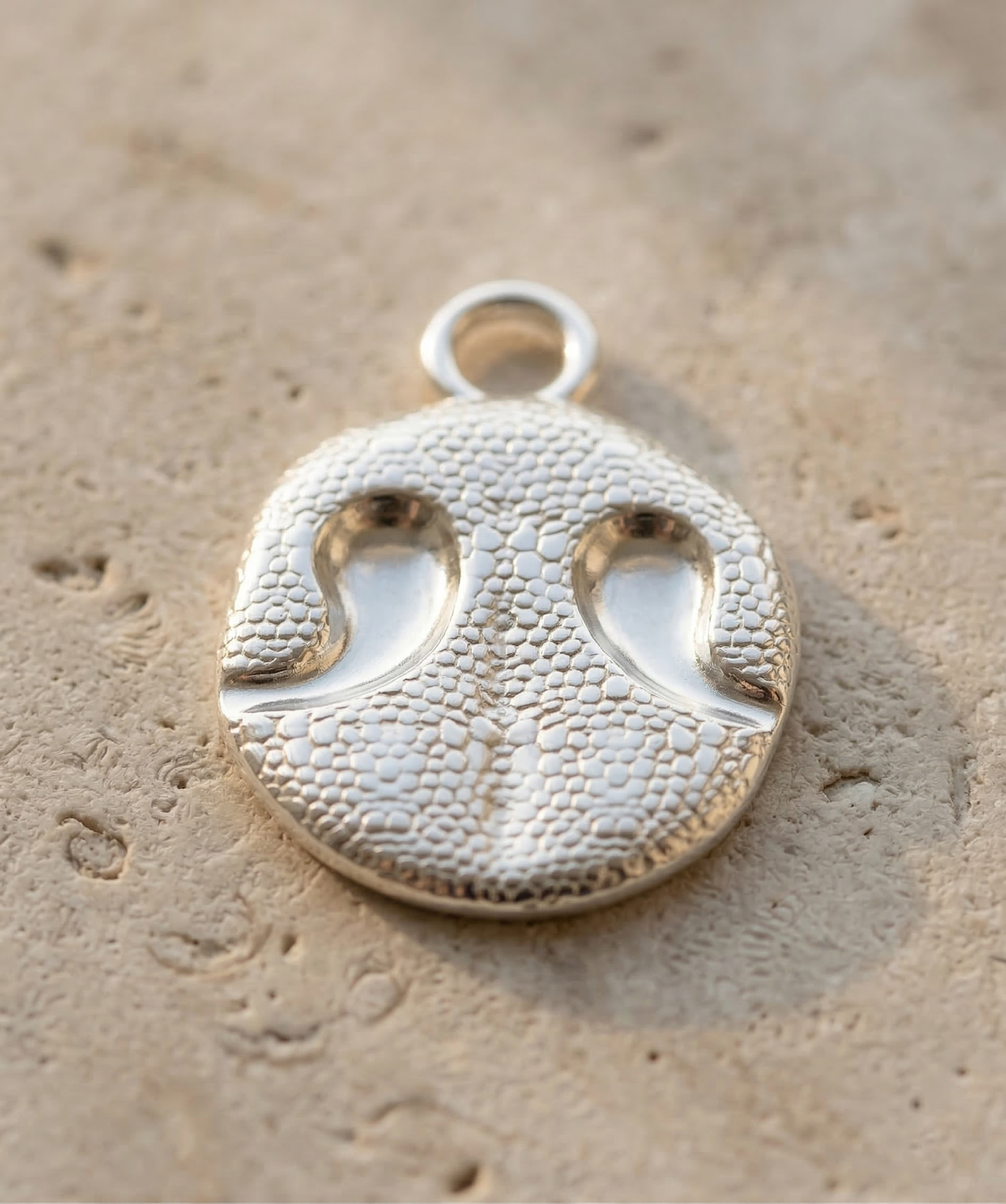 Sterling silver dog noseprint keychain inspired by a real dog's nose imprint, showing textured bumps and nostril details.