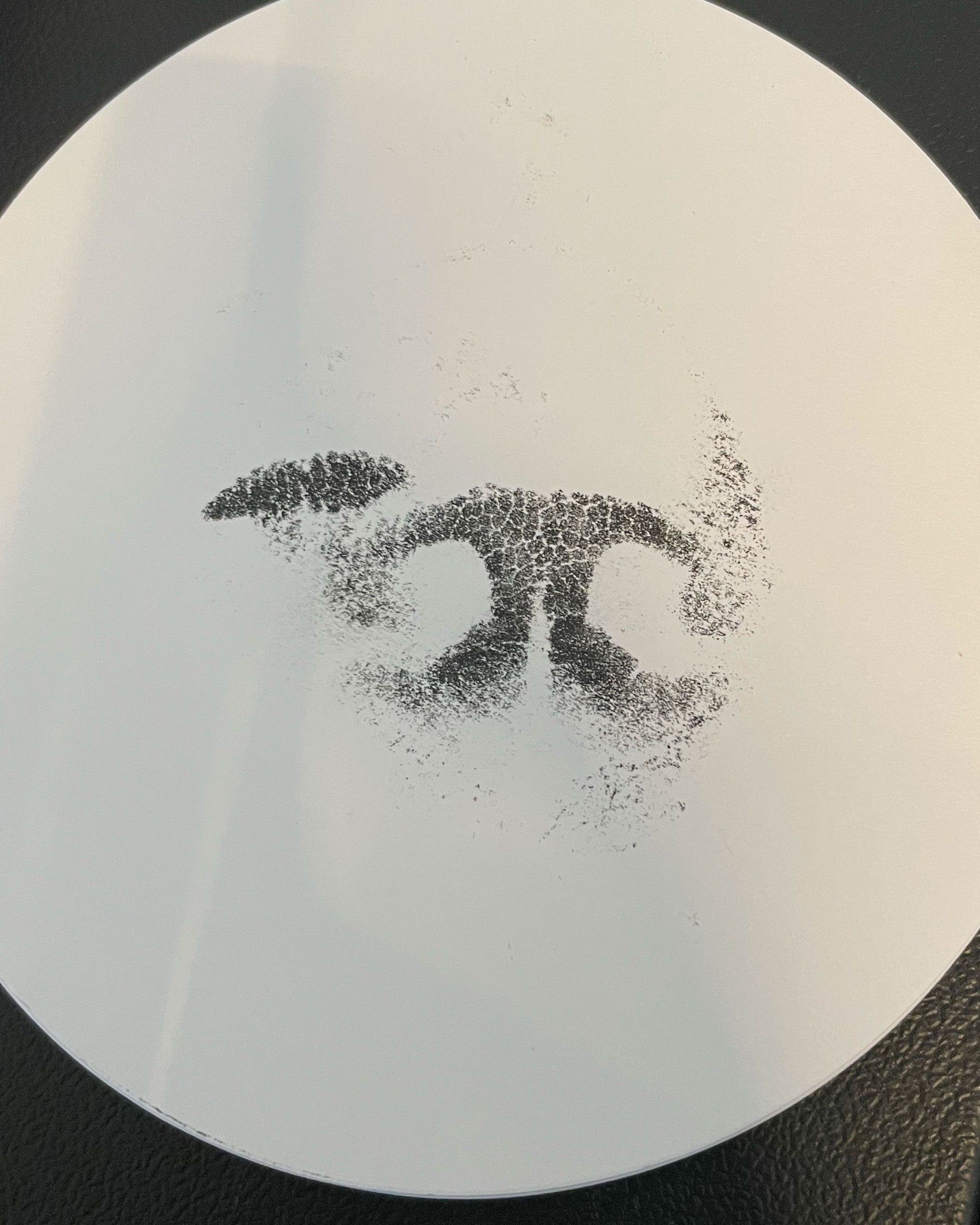 Black ink imprint of a dog’s nose print on white paper used as the reference for a custom engraved pendant.